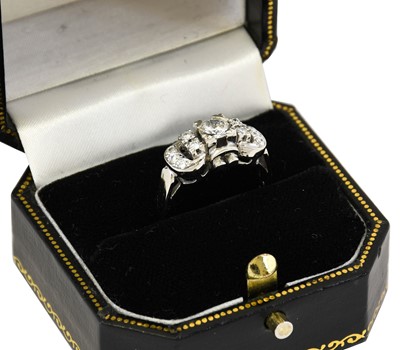 Lot 1047 - A diamond cluster ring, the buckle motif set...