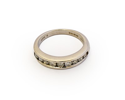 Lot 1057 - An 18 carat white gold diamond half hoop ring,...