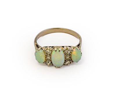 Lot 1031 - An opal and diamond ring, three graduated oval...