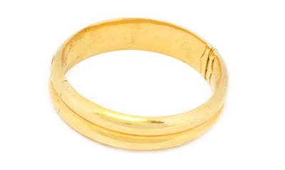 Lot 1038 - A hinged bangle, formed of two yellow plain...