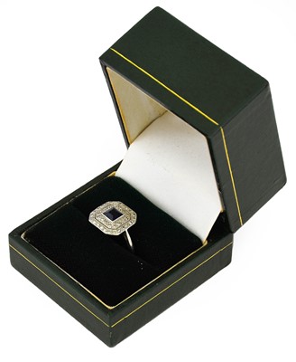 Lot 1066 - A sapphire and diamond cluster ring, the...