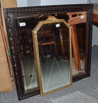 Lot 1282 - A carved oak framed wall mirror with bevelled...