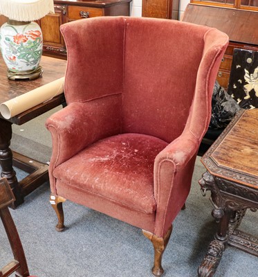 Lot 1351 - A George III style wingback armchair, late...
