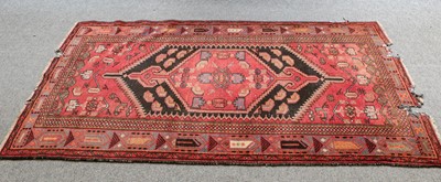 Lot 1207 - A Baluch rug, the chocolate brown field with...