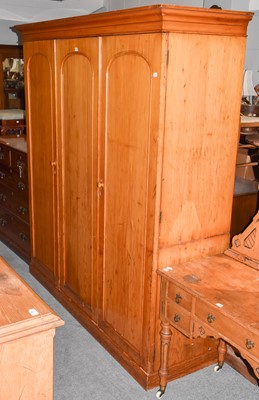 Lot 1396 - A 19th century pine triple wardrobe, fitted...