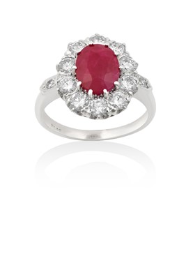Lot 2009 - A Ruby and Diamond Cluster Ring the oval cut...