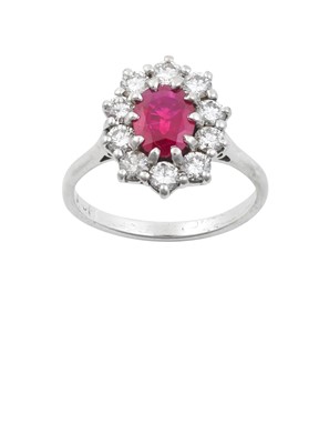 Lot 2233 - A Ruby and Diamond Cluster Ring the oval cut...