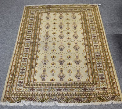 Lot 1107 - "Bukhara" Rug, the soft olive green field of...