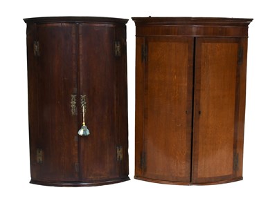 Lot 1176 - Two Georgian Oak Bow-fronted Corner Cabinets,...