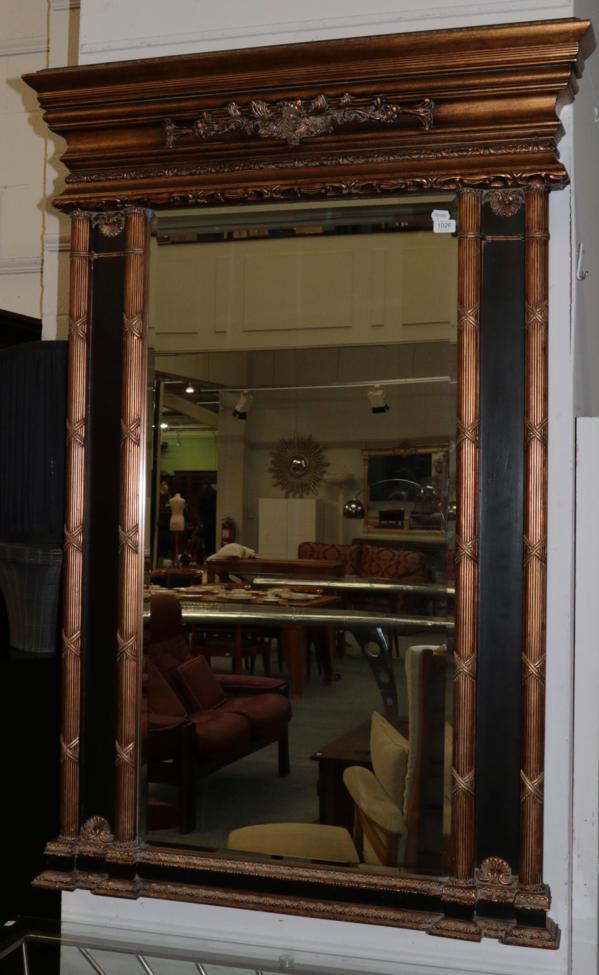 Lot 1026 - A Gilt Bevel Glass Mirror, the rectangular frame surrounded by reeded pilasters, the base with...